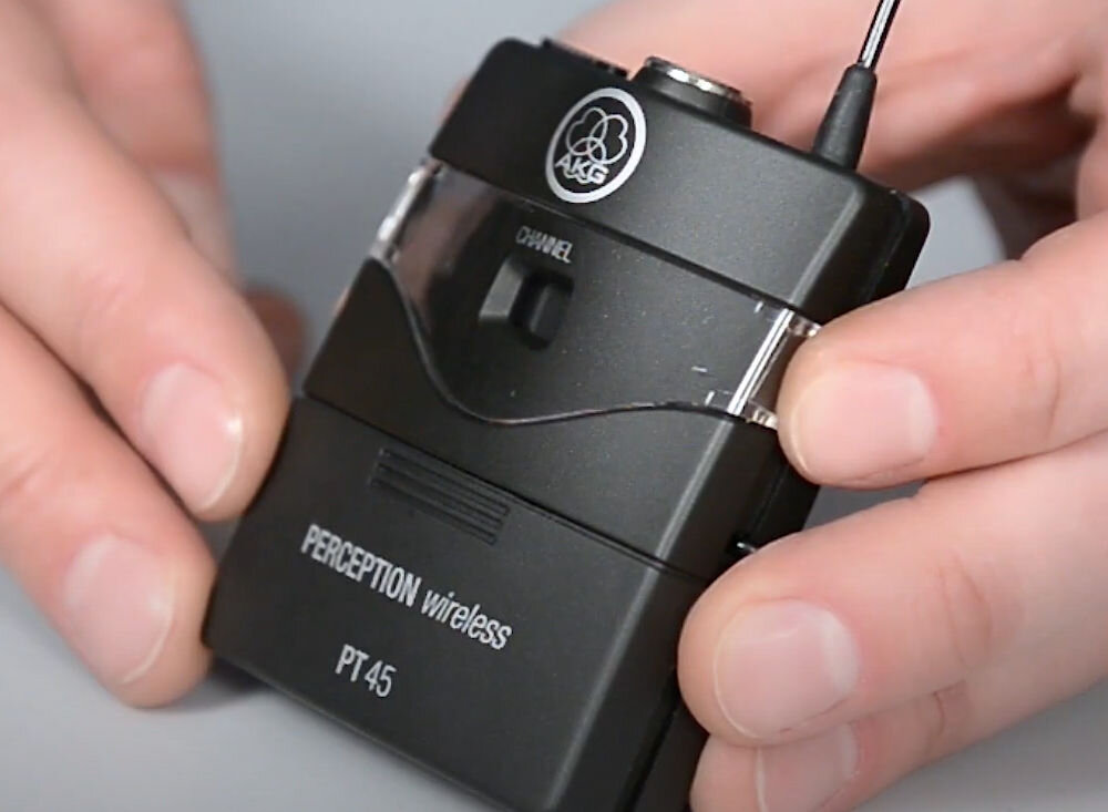 Zestaw bezprzewodowy AKG WMS45 Sport Set Band A prezentacja nadajnika trzymanego w dłoniach prezentacje szkolenia zajęcia fitness mikrofon na uchwycie nagłownym nadajnik bodypack PT45 odbiornik SR45