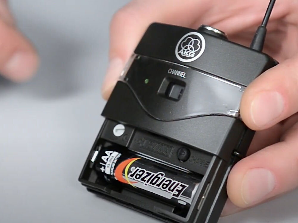 Zestaw bezprzewodowy AKG WMS45 Sport Set Band A Czarny prezentacja nadajnika ze zdjętą pokrywą pokazana bateria w środku czas pracy nadajnika wygodne rozwiązanie