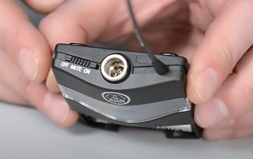 Zestaw bezprzewodowy AKG WMS45 Sport Set Band A pokazanie przełącznika wyciszenia urządzenie trzymane w dłoniach zintegrowany przełącznik wyciszenia jednym ruchem odcina sygnał z mikrofonu praktyczne rozwiązanie