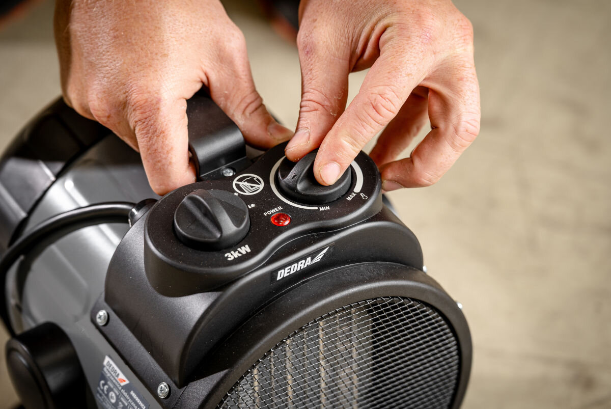 Nagrzewnica elektryczna DEDRA DED9931C2, moc, ekonomia, przepływ, oszczędność, Zbliżenie na rozgrzany ceramiczny panel grzejny nagrzewnicy DEDRA DED9931C2, pomarańczowy żar.