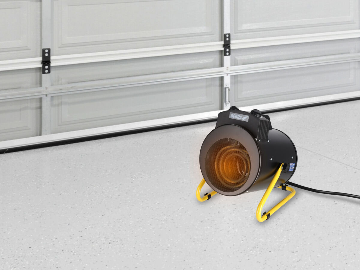 Nagrzewnica elektryczna DEDRA DED9932B, przegrzanie, IP24, metal, ochrona, Aktywna nagrzewnica DEDRA DED9932B ogrzewa jasny garaż, żółty stojak, widoczny żar wewnątrz.