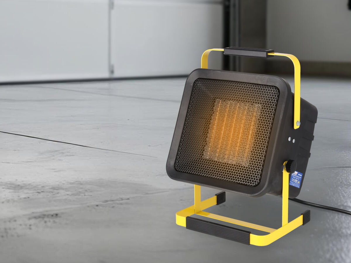 Nagrzewnica elektryczna DEDRA DED9931C3, ochrona, IP20, metal, trwałość, Nagrzewnica Dedra DED9931C3 w garażu na szarej posadzce, widoczny żarzący się panel PTC.