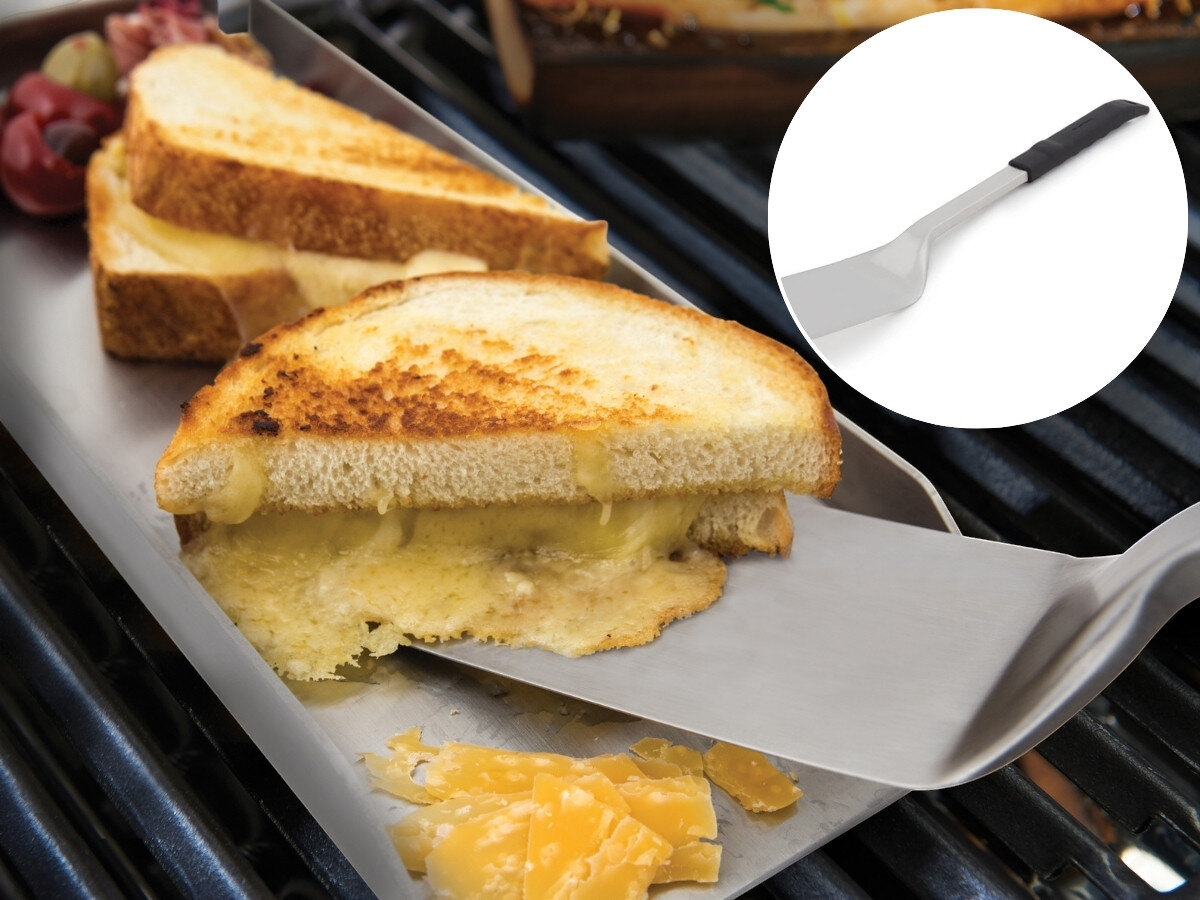 Zestaw do grillowania BROIL KING 64003, łopatka, grill, potrawy, obracanie, Grillowany tost z serem na stalowej blasze obok grilla, podnoszony stalową łopatką Broil King, z winogronami w tle i zbliżeniem na łopatkę.