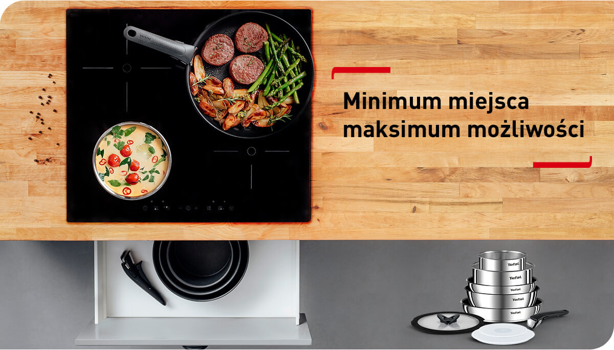 Na obrazie widać patelnię z jedzeniem na płycie indukcyjnej oraz napis \'Minimum miejsca maksimum możliwości\'. Obok znajduje się zestaw naczyń kuchennych ułożonych w stos.