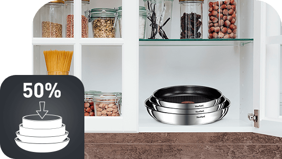 W szafce kuchennej znajdują się trzy patelnie ułożone jedna na drugiej, obok słoików z makaronem i orzechami. Na obrazie widoczna jest także ikona z napisem \'50%\' i grafiką przedstawiającą stos patelni.