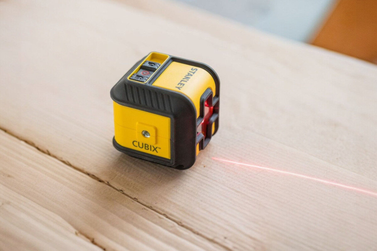 Laser krzyżowy STANLEY Cubix STHT77648-1, wahadło, poziom, czas, praca, Laser stoi na drewnianym blacie