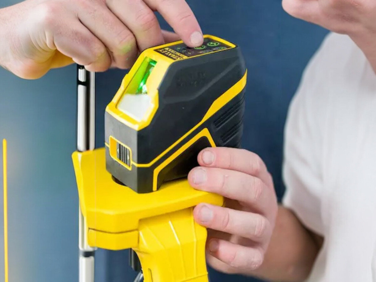 Laser krzyżowy STANLEY FMHT77586-1, pion, poziom, wahadło, błąd, Włączanie lasera Stanley na żółtym statywie.