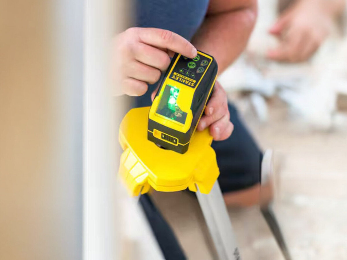 Laser krzyżowy STANLEY FMHT77586-1, schody, skos, blokada, optyka, Zbliżenie na przyciski sterujące lasera.