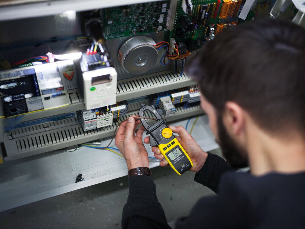 Miernik cyfrowy STANLEY FMHT82564-0, miernik, pomiar, prąd, ekran, mężczyzna sprawdza pomiary instalacji dzięki miernikowi