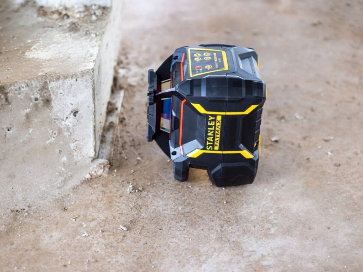 Niwelator laserowy STANLEY FMHT77449-1, IP66, woda, odporność, praca, Niwelator laserowy Stanley pracujący w pozycji leżącej na surowym, betonowym podłożu.