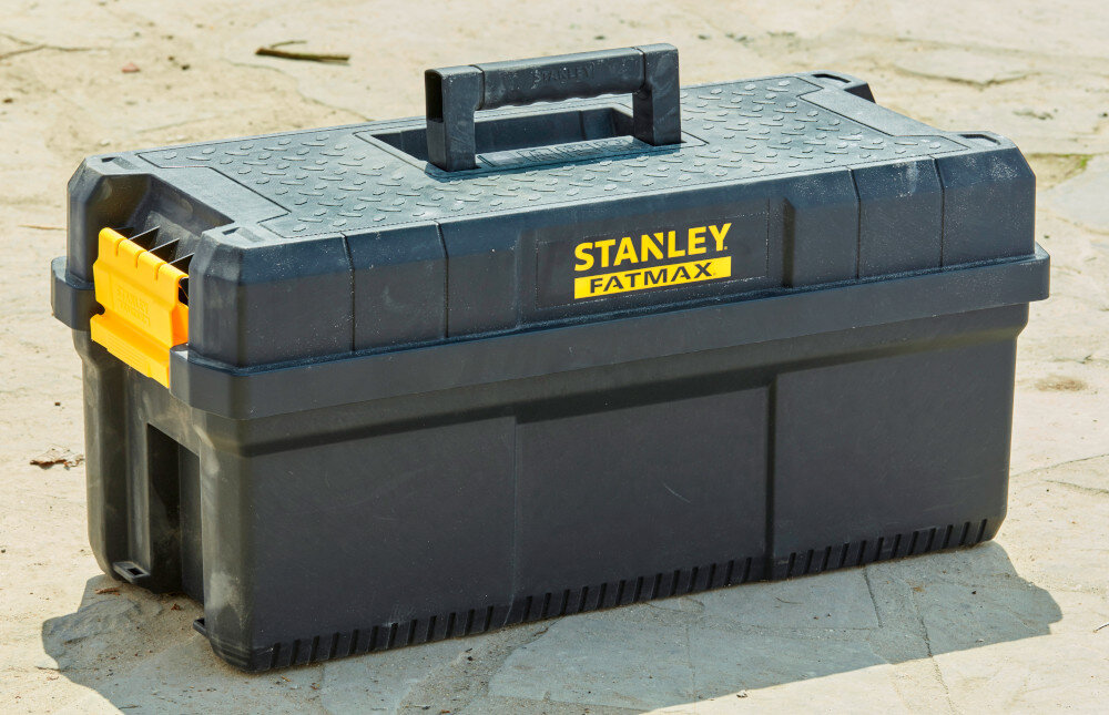 Skrzynka narzędziowa STANLEY 81083-1 plac budowy skrzynia ustawiona na ziemi organizacja pracy praktyczny gadżet transport mobilność przechowywanie