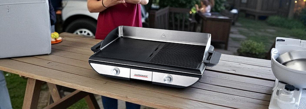 Grill elektryczny GASTROBACK 42523, gotowanie, grillowanie, smażenie, ogród, grill stoi na blacie stoły drewnianego na tarasie