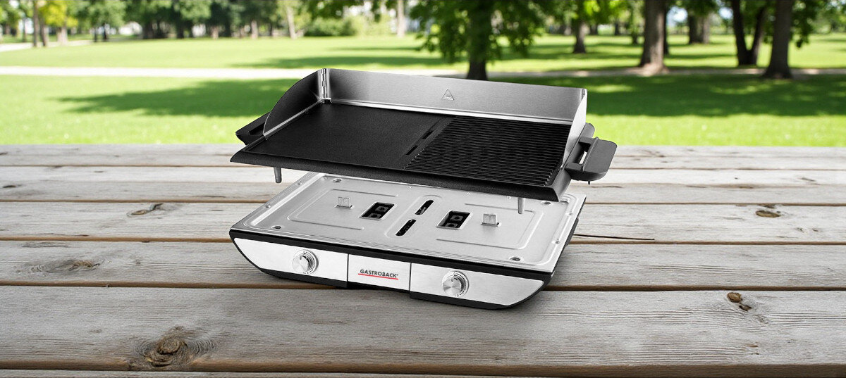 Grill elektryczny GASTROBACK 42523, odlewanie, ciśnieniowe, czyszczenie, przypalenia, wizualizacja odsperowania płyty grillowej od podstawy, stojącej na stole drewnianym w ogrodzie