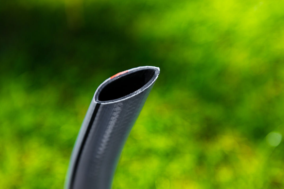 Wąż ogrodowy NEO Optima 3/4 50 m 15-825, skręcanie, załamania, system, żywotność, w tle trawnik, zbliżenie na końcówkę węża