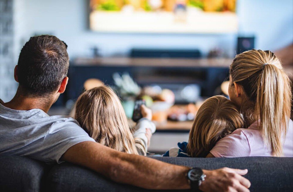 Router TP-LINK TL-WR844N Czteroosobowa rodzina siedząca na kanapie, oglądająca wspólnie telewizję; widoczna tylna część ciał i ekran w oddali, kontrola rodzicielska, funkcje