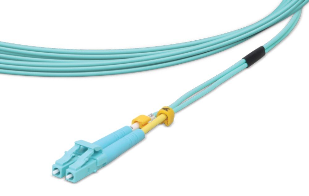 Kabel patchcord UBIQUITI UOC-3 Zbliżenie na końcówkę kabla światłowodowego z dwoma jasnoniebieskimi złączami typu LC spiętymi razem klipsem i oznaczonymi żółtymi pierścieniami na przewodach