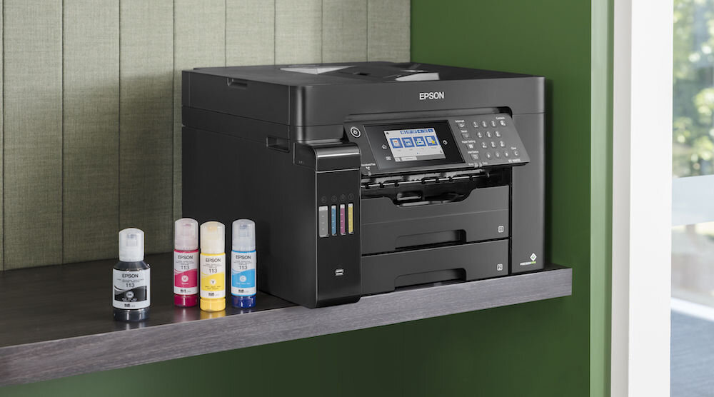 Urządzenie wielofunkcyjne EPSON EcoTank L15150 Druk w kolorze, Automatyczny druk dwustronny, Wi-Fi prezentacja urządzenia na półce obok butelki z atramentem zielona ściana formaty BMP JPEG TIFF PDF PNG dostosowanie