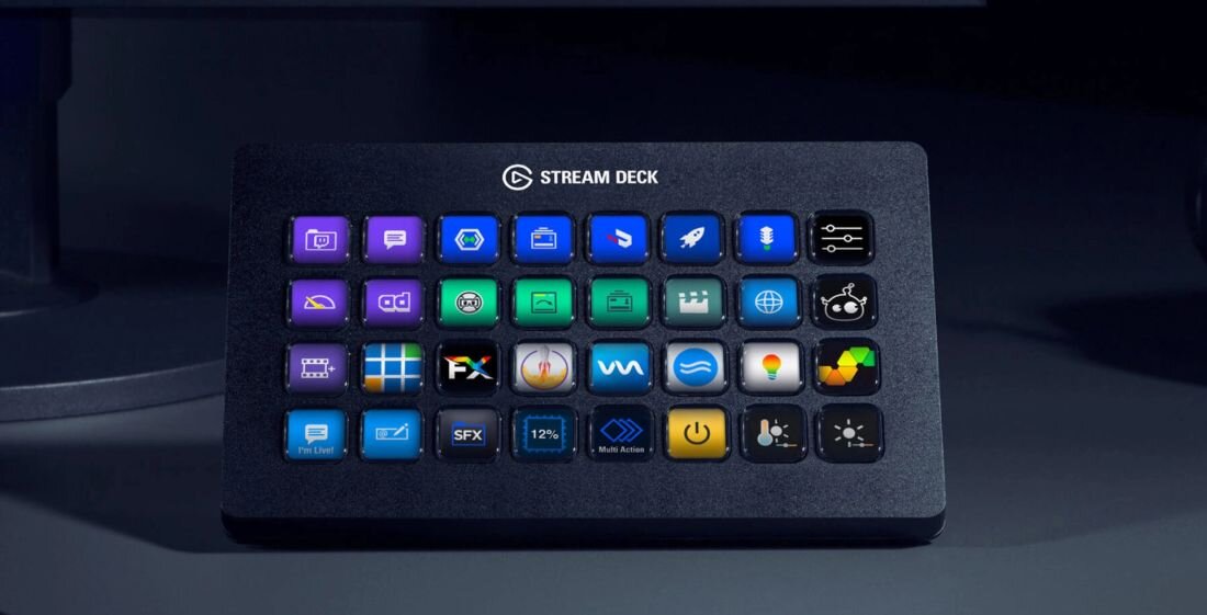 Na obrazie widoczny jest panel z wieloma kolorowymi przyciskami, oznaczony napisem \'STREAM DECK\'. Każdy przycisk ma inny symbol, sugerujący różne funkcje.