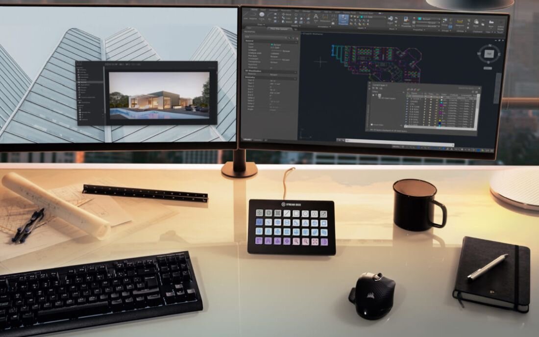 Na biurku znajduje się panel z przyciskami oznaczony logo \'Elgato Stream Deck XL\', obok klawiatury, myszki i notatnika. W tle widoczne są dwa monitory z wyświetlonymi programami graficznymi.