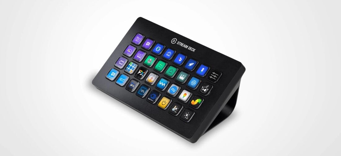 Na obrazie widoczny jest panel z wieloma kolorowymi przyciskami, każdy z ikoną, na czarnej podstawce. Na górze panelu znajduje się logo \'STREAM DECK\'.