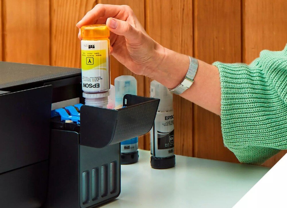 Urządzenie wielofunkcyjne EPSON EcoTank L14150 osoba uzupełniająca zbiornik z atramentem przykładając butelkę z tuszem do otworu zbiornika uzupełnianie blokada