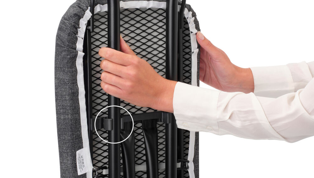 Deska do prasowania BRABANTIA 134203 Denim Blue 110 x 30 cm osoba trzyma zamkniętą deskę czarne metalowe elementy białe tło  wygodne przechowywanie i transport blokada transportowa bezpieczne złożenie blokada dziecięca zapobieganie przypadkowemu otwarciu dodatkowe bezpieczeństwo w domu łatwa do przechowywania małe przestrzenie 