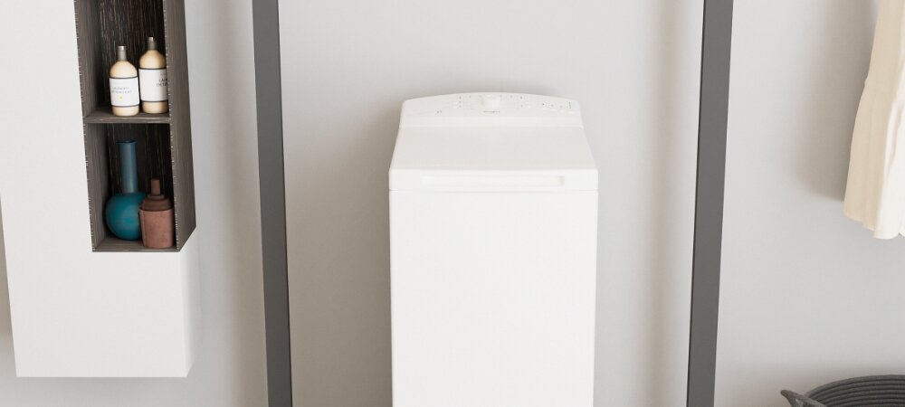 Biała pralka ładowana od góry stoi w jasnym pomieszczeniu. Obok znajduje się półka z kilkoma butelkami i dekoracyjnymi elementami.