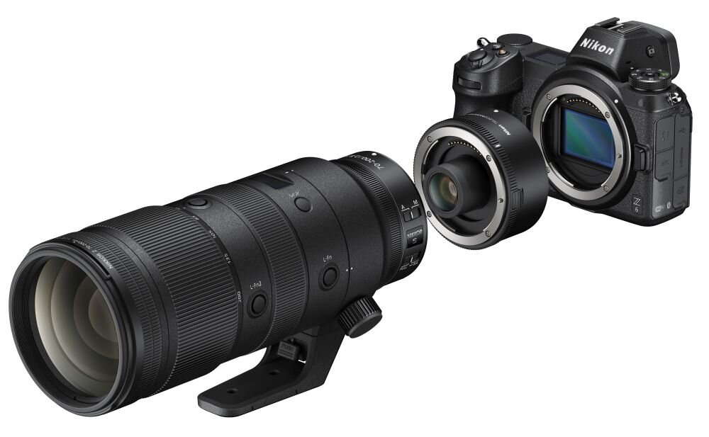 Na obrazie widoczny jest aparat fotograficzny z wymiennym obiektywem oraz telekonwerterem. Na aparacie znajduje się logo \'Nikon\'.