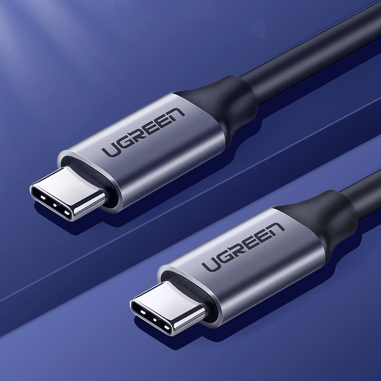 Na obrazie widoczne są dwa szare kable USB-C z metalowymi końcówkami, na których znajduje się logo \'UGREEN\'.