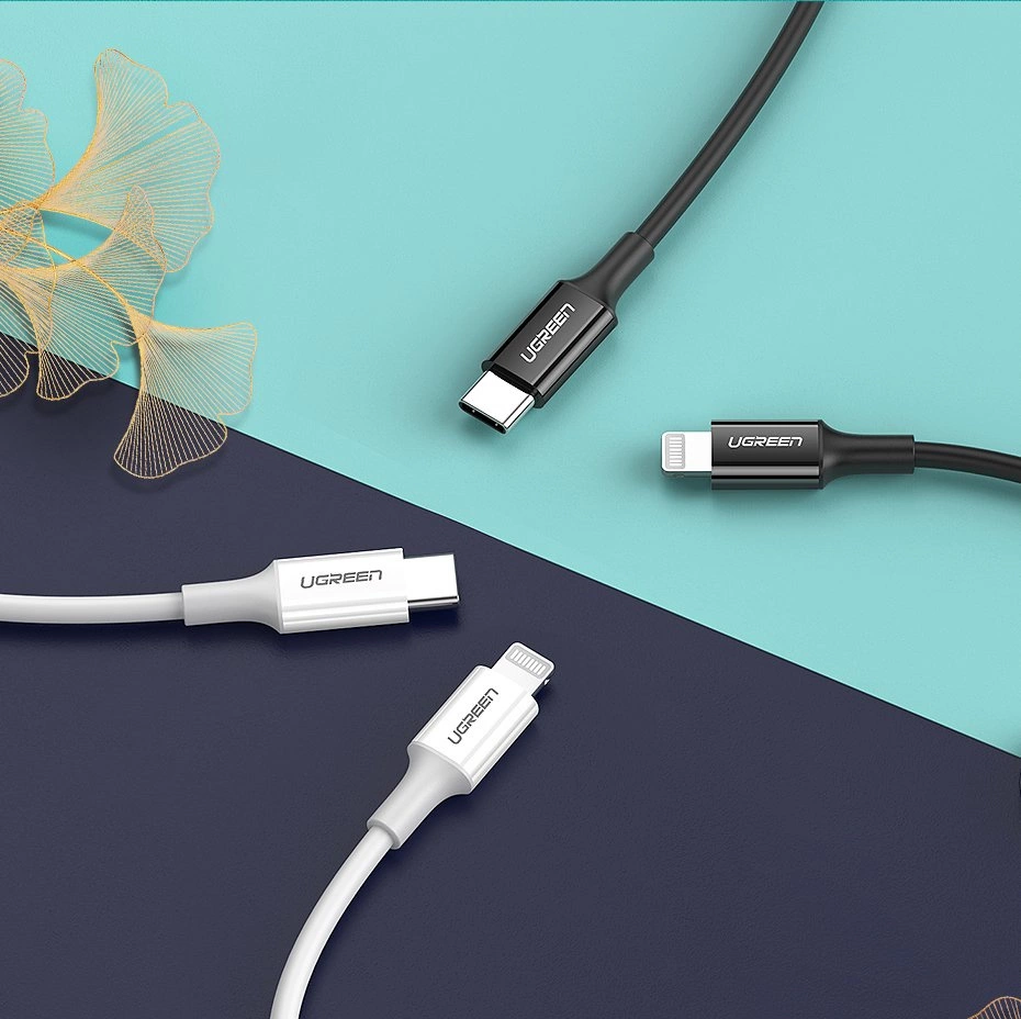 Na obrazie widoczne są cztery kable z końcówkami USB-C i Lightning, w kolorach białym i czarnym, z logo \'UGREEN\'. Tło jest podzielone na dwa kolory: turkusowy i granatowy.
