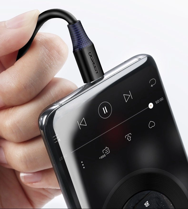 Osoba trzyma smartfon z podłączonym kablem USB, na ekranie widoczne są ikony odtwarzacza muzyki. Na wtyczce kabla widnieje napis \'UGREEN\'.