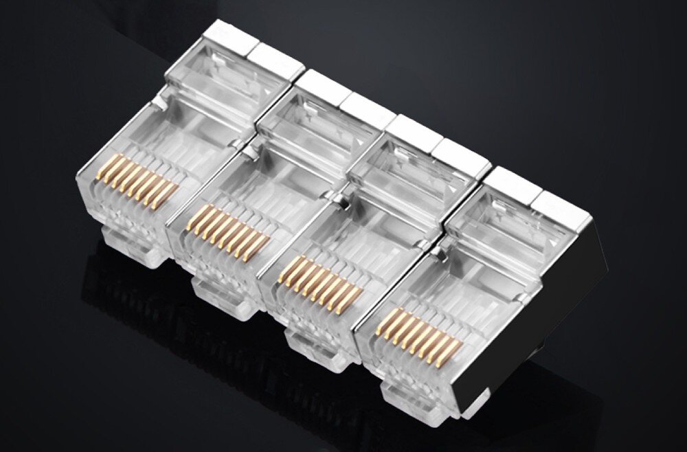 Wtyk UGREEN 20333 Cztery metalowe wtyki RJ45 ustawione w równym rzędzie jeden obok drugiego na ciemnym tle