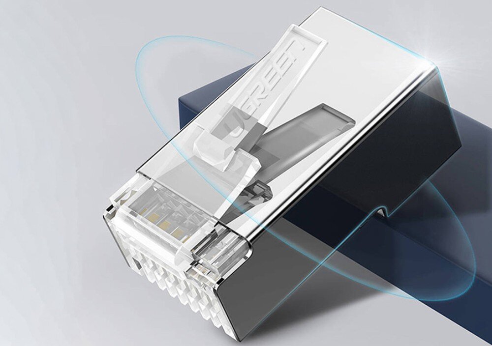 Wtyk UGREEN 20333 Zbliżenie na pojedynczy metalowy wtyk RJ45 z widocznym napisem 'UGREEN' na plastikowym zatrzasku, umieszczony na szarym tle z niebieskim akcentem kolorystycznym