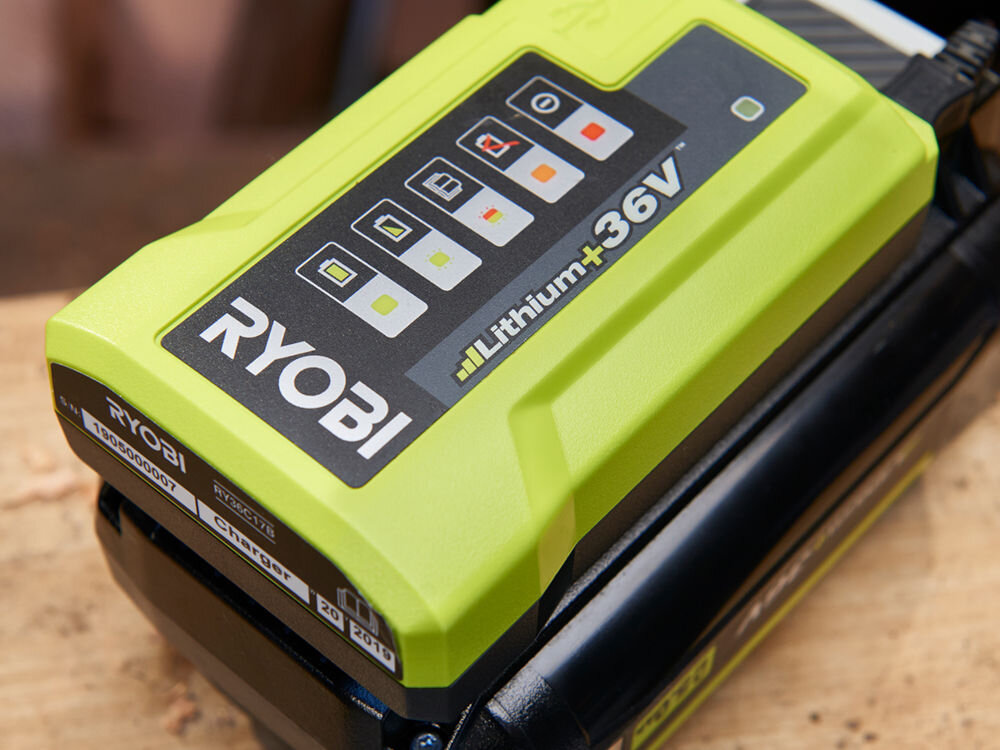 Ładowarka RYOBI RY36C17A 36V 1.7A, monitorowanie, napięcie, przegrzanie, ładowanie, Zbliżenie od góry na ładowarkę stojącą na blacie warsztatowym