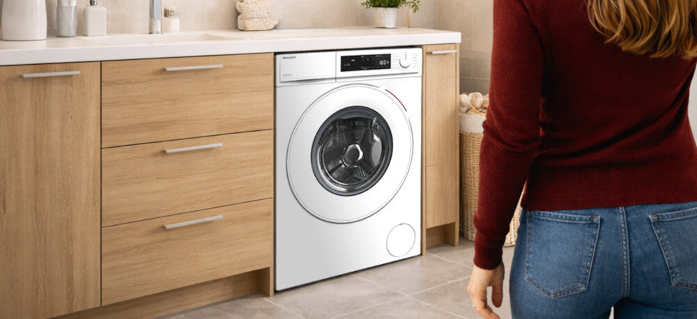 PRALKA SHARP ES-HFM6102WD Pralka wbudowana pod blat w łazience pokazana w realistycznym wnętrzu. Ujęcie akcentuje dopasowanie do małych przestrzeni zabezpieczenie przed dziećmi kontrola niewyważenia ochrona przed przepełnieniem wykrywanie awarii bezpieczeństwo użytkowania stabilna praca