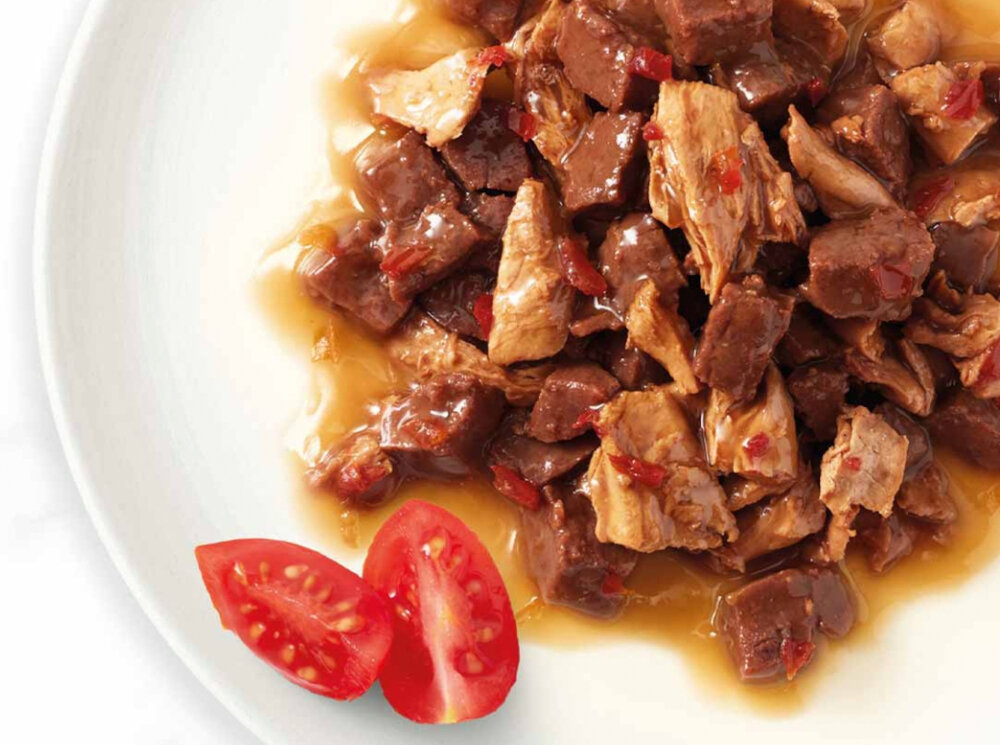 Karma dla kota GOURMET Casserole Wołowina i kurczak w sosie pomidorowym 85 g widok z góry talerz z karmą jasne tło napis Gold smak karma dla kota pełnoporcjowe danie