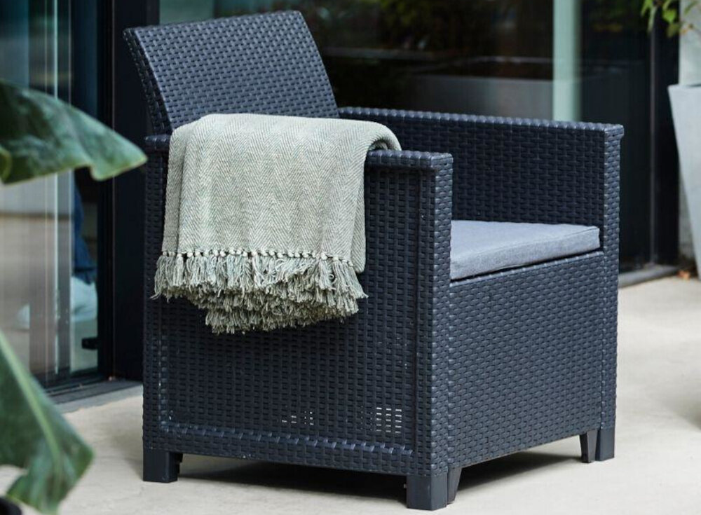 Zestaw mebli ogrodowych KETER Emma 246157 Cappuccino fotel na tarasie na fotelu zawieszony koc w tle dom dwa fotele o wymiarach 65 x 63 x 74 cm każdy obciążenie do 110 kg wygodne oparcia gładkie podłokietniki dodatkowe miejsca do siedzenia relaks