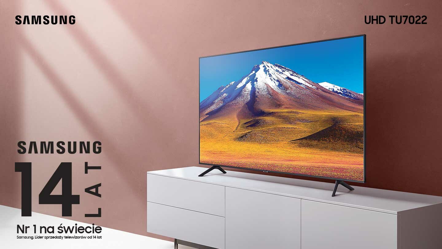 Telewizor TU7022 4K stoi na komodzie RTV na tle różowej ściany Telewizor TU7022 4K stoi na komodzie RTV na tle różowej ściany