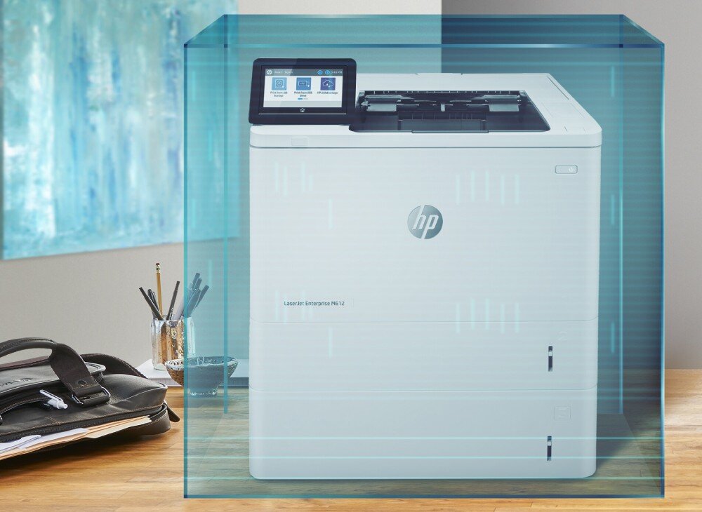 Drukarka HP LaserJet Enterprise M612dn Automatyczny druk dwustronny Drukarka otoczona niebieską siatką symbolizującą strefę ochronną, stoi na biurku obok plecaka i przyborów biurowych, bezpieczeństwo, funkcje