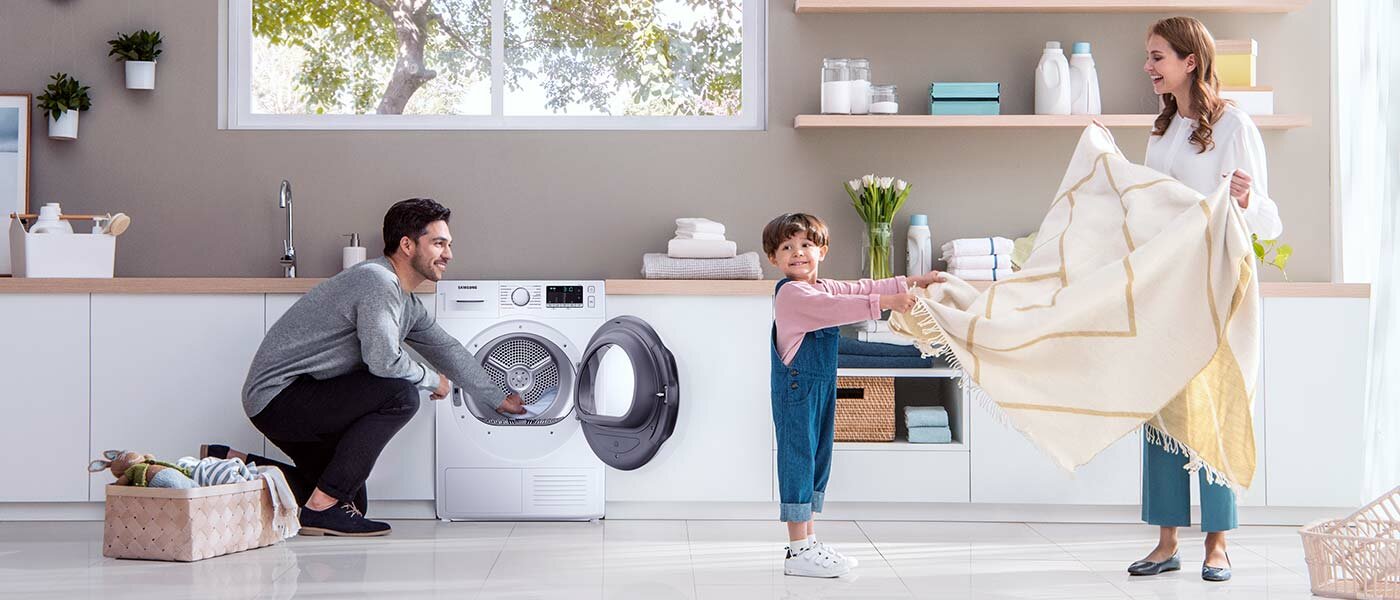 Rodzina wyjmuje pranie z suszarki  Rodzina wyjmuje pranie z suszarki