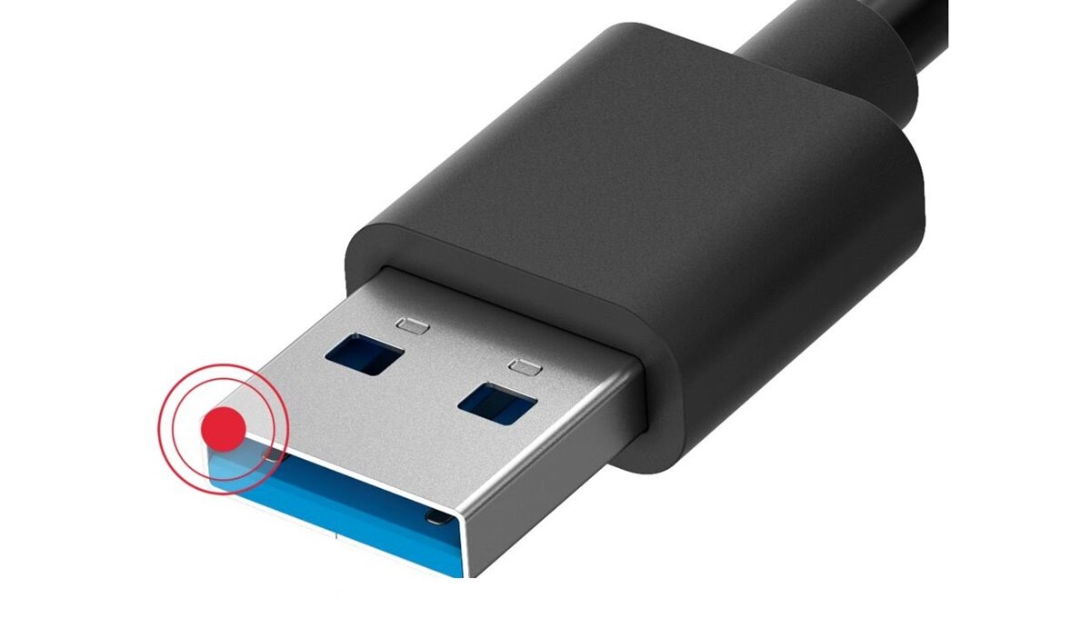 Na obrazie widoczny jest czarny kabel z końcówką USB-A, której wnętrze jest niebieskie. Obok końcówki znajduje się czerwony okrąg z punktem w środku.