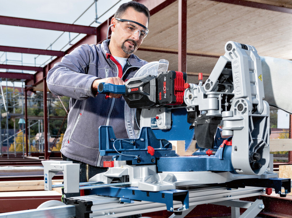 Pilarka ukosowa BOSCH Professional GCM 18V-305 GDC 0601B43000 średnica tarczy 305mm 18V osoba na budowie pracuje pilarką solidna budowa wysoka precyzja cięcia dla profesjonalistów do użytkowania w przydomowym warsztacie wbudowane oświetlenie LED dobra widoczność linii cięcia