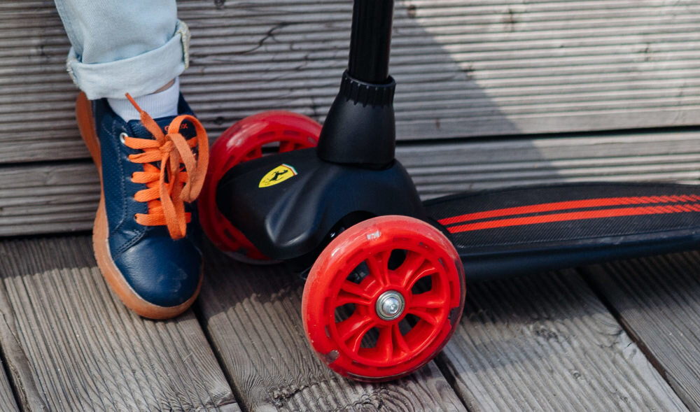Hulajnoga dla dzieci FERRARI FXK5 Czarny zbliżenie na przednie kółka kola z materialu PU lozyska ABEC-7 plynna jazda trwalosc przednie kolo srednica 12 cm tylne kolo srednica 8 cm stabilnosclatwe manewrowanie odpornosc na scieranie dobre tlumienie wstrzasow