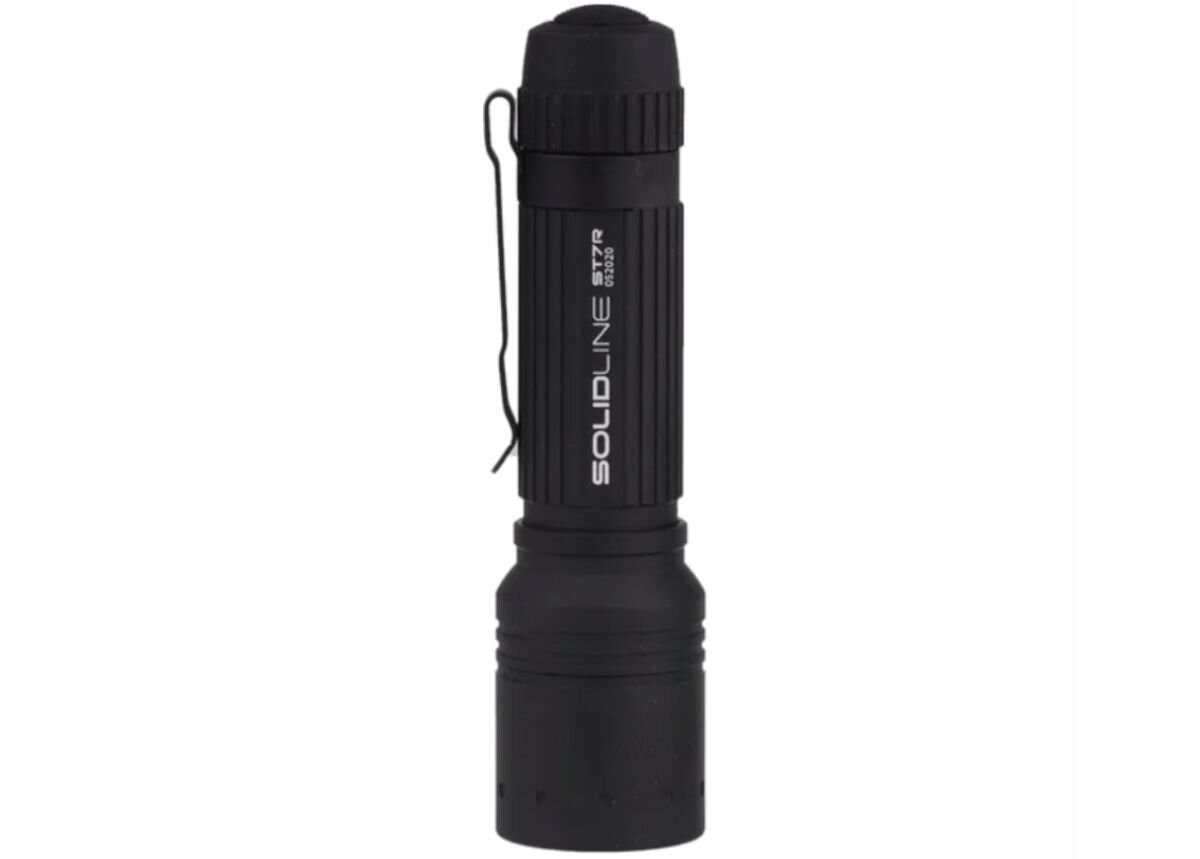 Latarka LEDLENSER Solidline ST7R, Prążkowana, powierzchnia, warunki, klips, na białym tle latarka stoi pionowo od strony diody