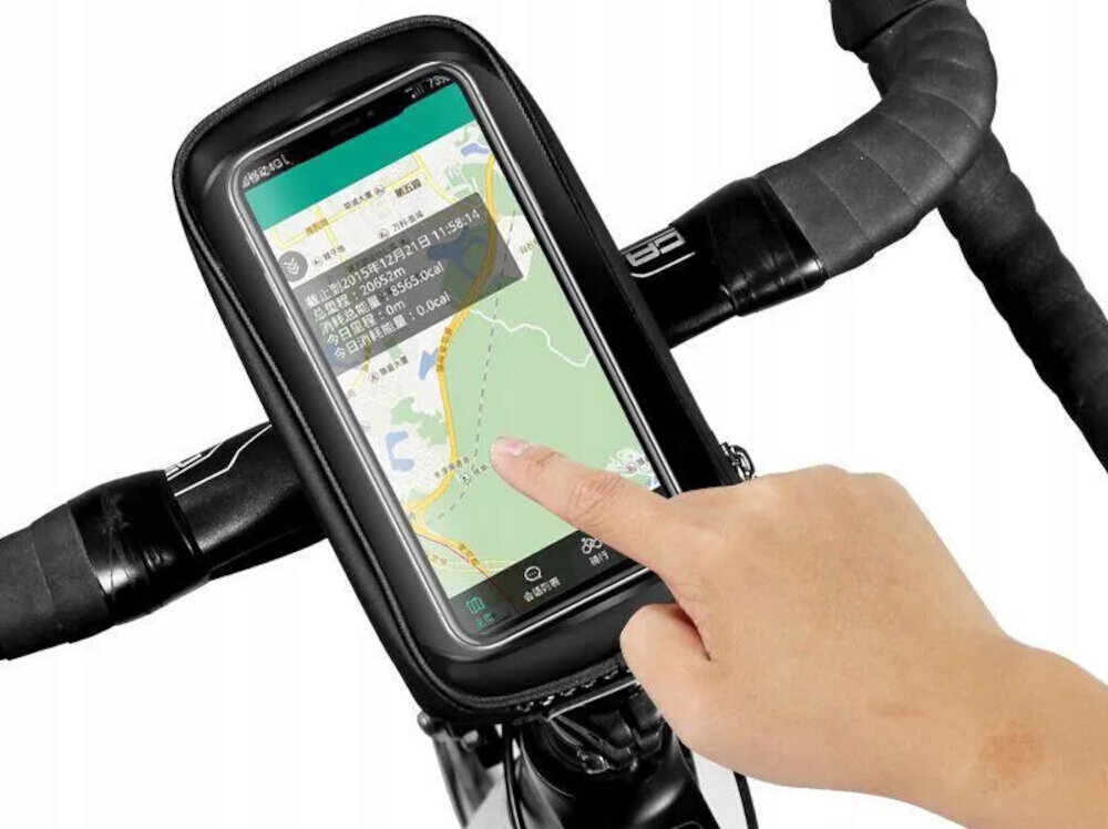 Na zdjęciu widać torbę rowerową zamontowaną na kierownicy, w której znajduje się smartfon z wyświetloną mapą. Osoba dotyka ekranu telefonu, na którym widoczny jest tekst w języku chińskim.