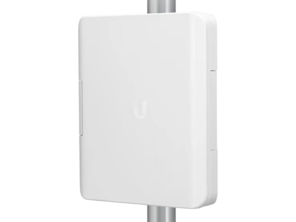 Obudowa UBIQUITI USW-Flex-Utility Obudowa USW-Flex-Utility zamontowana pionowo na srebrnym maszcie, widoczna pod lekkim kątem, prezentująca gładki front i zamkniętą konstrukcję chroniącą przed warunkami atmosferycznymi