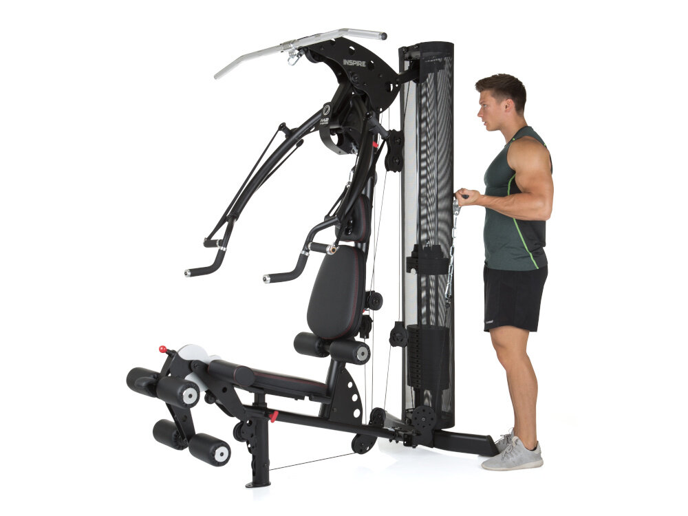 Atlas FINNLO Maximum Inspire M2 urządzenie na białym tle osoba stoi ćwicząc budowanie sylwetki trening w domu wszechstronny trening trening całego ciała kondycja zdrowie
