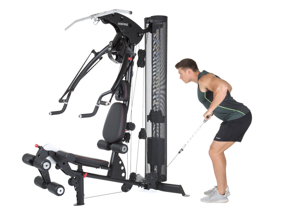 Atlas FINNLO Maximum Inspire M2 urządzenie na białym tle osoba stoi ćwicząc wykonanie ponad 100 ćwiczeń trening siłowy i funkcjonalny dla początkujących i zaawansowanych użytkowników bezpieczne wykonywanie ćwiczeń bez nadmiernego obciążania stawów ergonomiczne uchwyty dobrze zaprojektowane stanowiska ćwiczeniowe