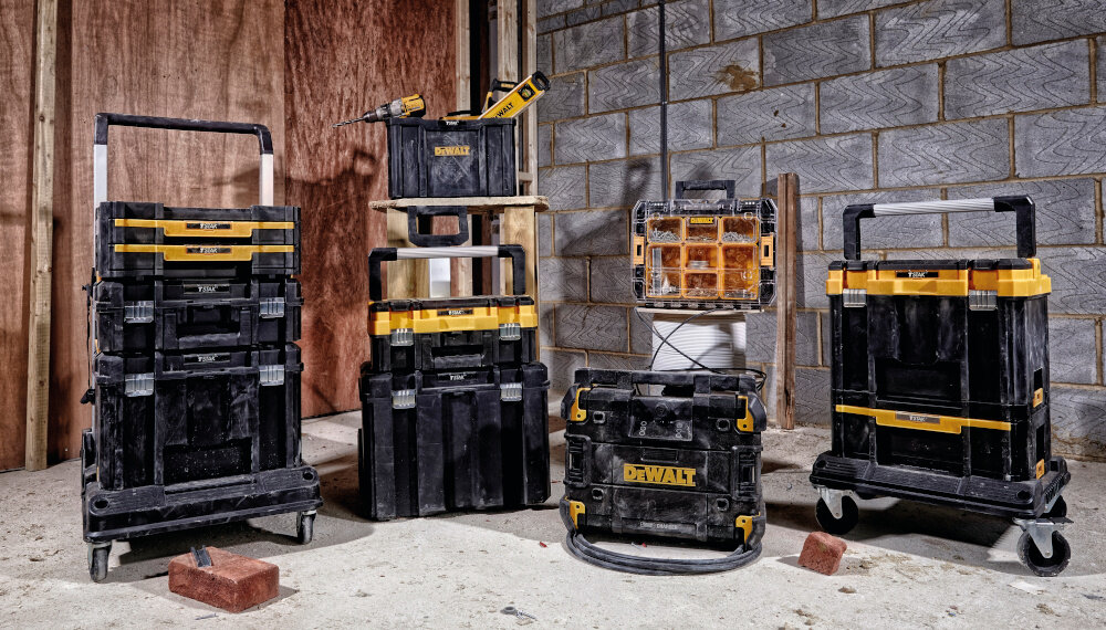 Skrzynka narzędziowa DEWALT DWST83395-1 magazyn ciemne tło skrzynka ustawiona na innej skrzyni obok inne skrzynie należące do systemu TSTAK porządek transport mobilność przechowywanie