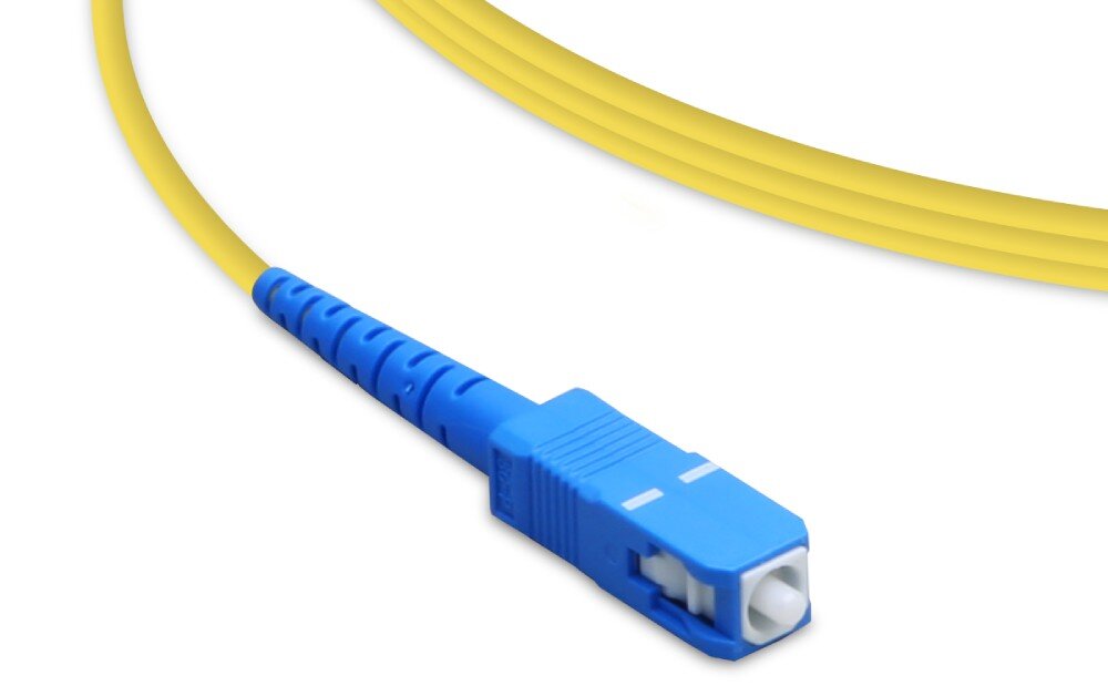 Kabel patchcord UBIQUITI UF-SM-PATCH-UPC-APC 1.5 m Zbliżenie na zieloną wtyczkę światłowodową umieszczoną na końcu żółtego przewodu